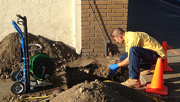 Garland plumber snakes a drain